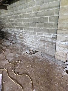 Water damage and efflorescence on basement wall illustrating waterproofing material failure.