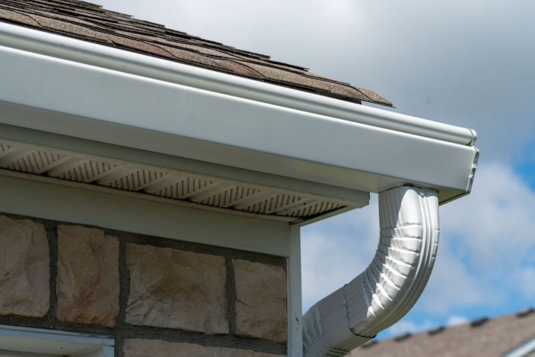 Clean gutter and downspout system directing rainwater away from a home's foundation