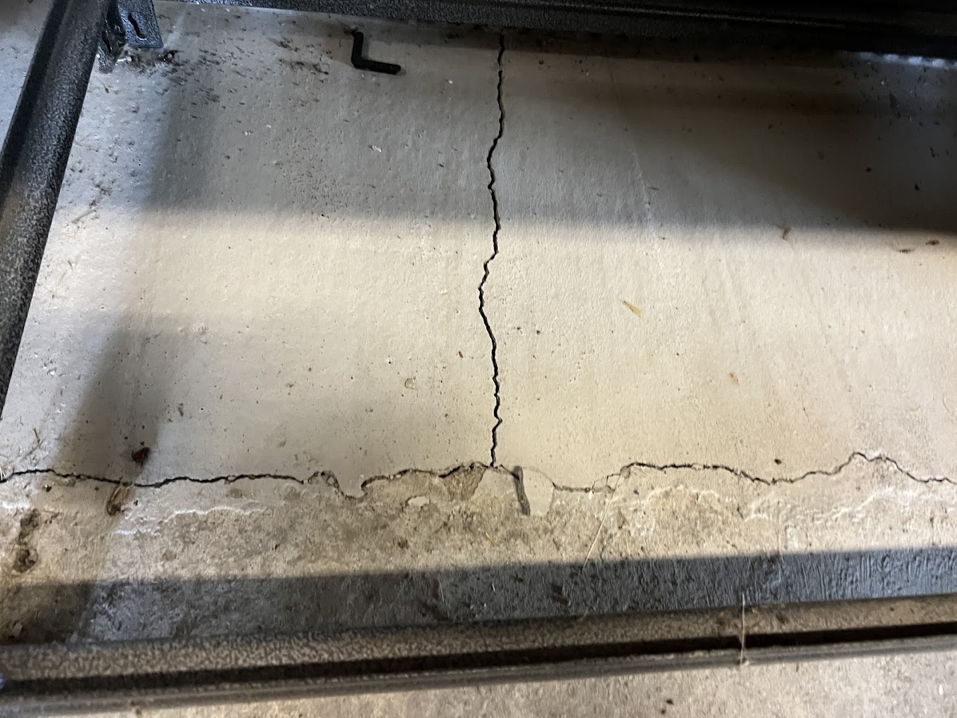 Vertical crack in a basement foundation wall showing signs of structural movement and possible bowing wall damage.