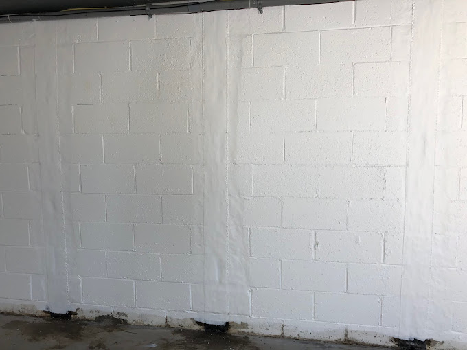 Freshly waterproofed basement wall with interior drainage system installed in a Pittsburgh home.